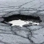 "Broken asphalt pavement resulting in a pothole, dangerous to motorists. Shot with shallow dof.  ....recent addition"